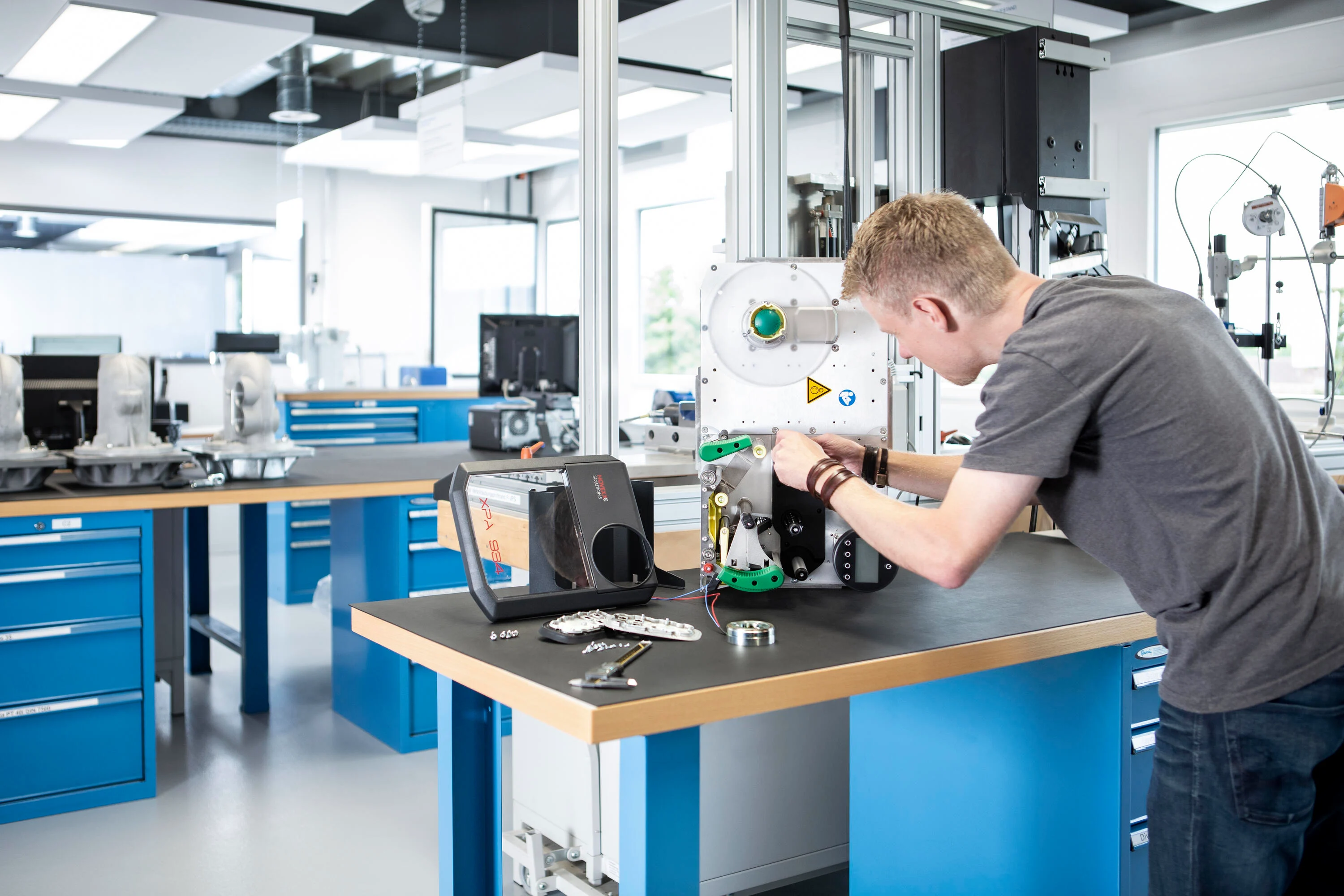 Engineer disassembling an application in a technical lab to analyze fasteners and joints. Key visual for Expert Teardown only.