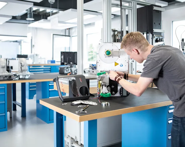 Engineer disassembling an application in a technical lab to analyze fasteners and joints. Key visual for Expert Teardown only.