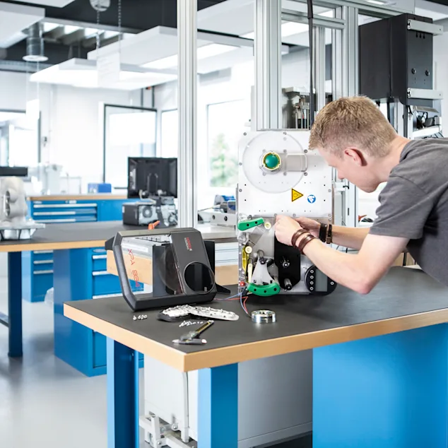 Engineer disassembling an application in a technical lab to analyze fasteners and joints. Key visual for Expert Teardown only.