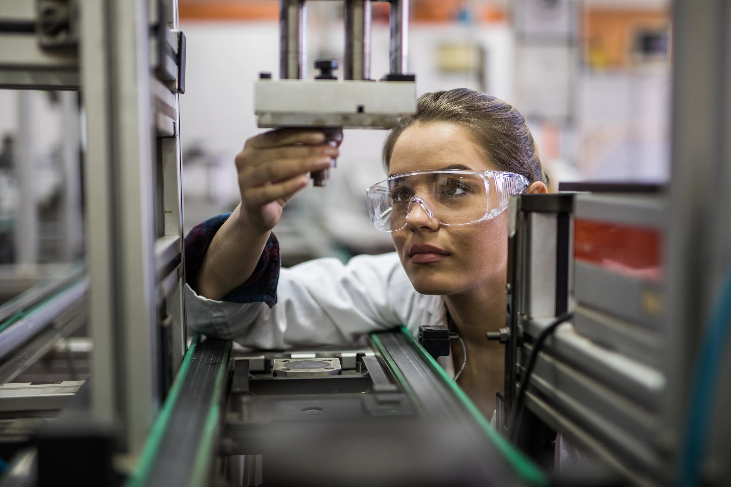 Quality control worker analyzing tool on a manufacturing machine.