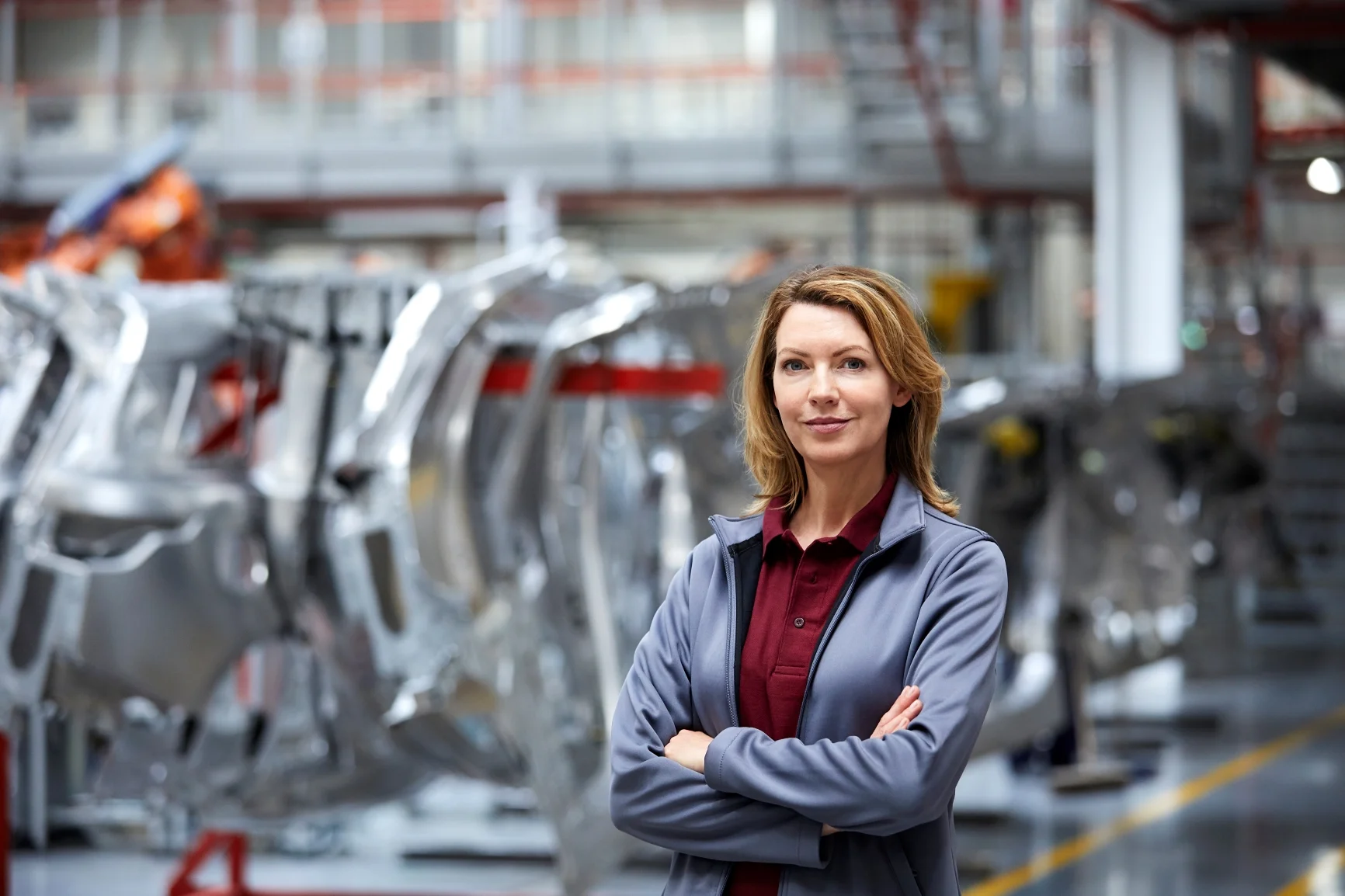 Female assembly manager standing in automotive production facility