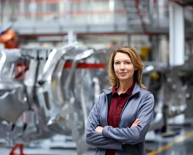 Female assembly manager standing in automotive production facility