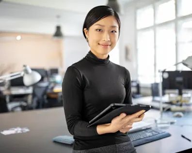 Female designer in her office, holding a tablet in her hands