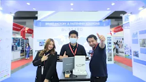 Három Bossard alkalmazott egy vásári standnál, egy "Smart Factory & Fastening Solutions" feliratú stand előtt, Bossard márkajelzéssel.