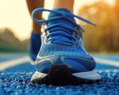 Laufschuh auf blauer Laufbahn mit Sonnenlicht