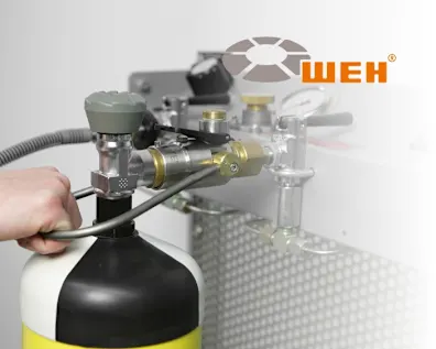 Gasflasche mit angeschlossenem WEH-Adaptersystem bei der Wartung, mit sichtbarer Hand und Bedienelement