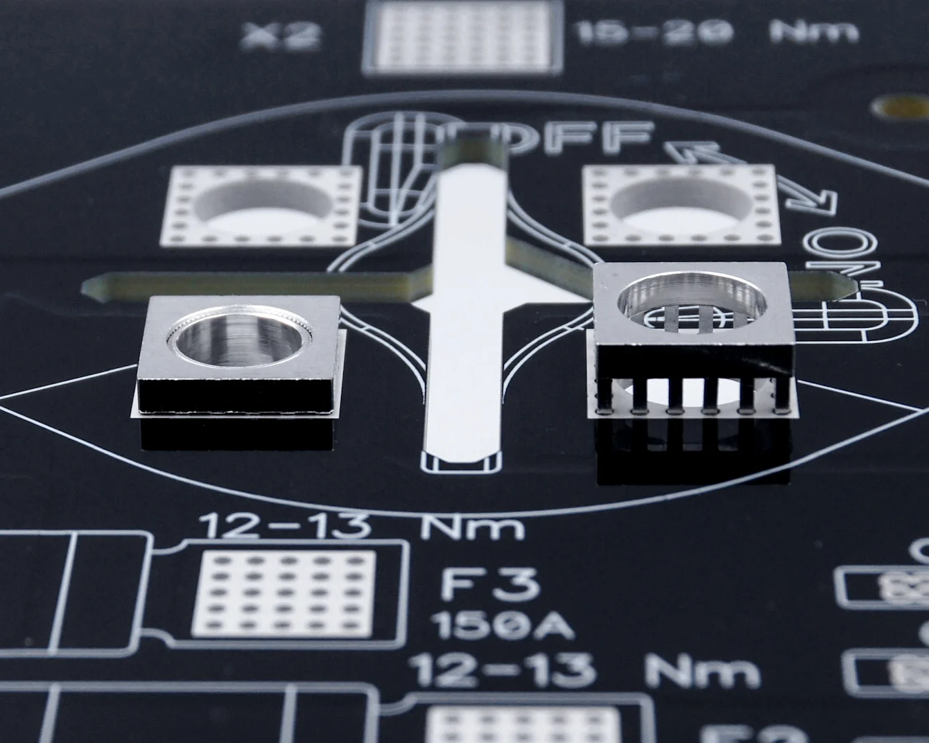 Gros plan d'un PCB noir avec des éléments d'alimentation MTCON, trois déjà pressés, un encore à assembler