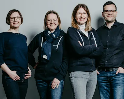 Vier Teammitglieder von Bossard Deutschland aus dem Bereich People & Organizational Development vor grauem Hintergrund.
