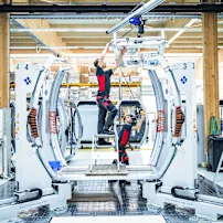 Techniker arbeiten an einer CWA-Kabine in einer modernen Produktionsanlage.