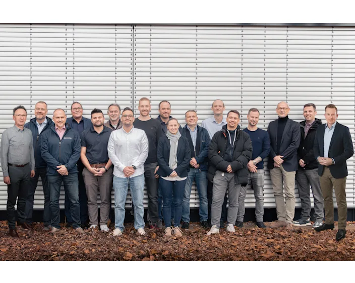 Gruppenfoto des Bossard TechDay Expertenteams vor einer Lamellenwand – bestehend aus 18 Personen aus Technik, Vertrieb und Beratung.
