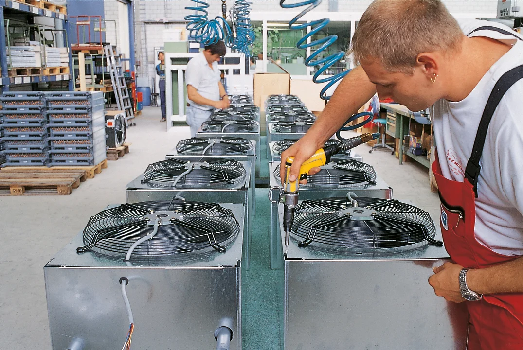 A man installing a DIN 7500 screw manually with a power driver