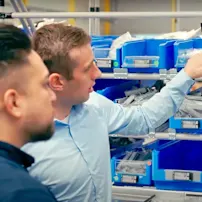 Hai người đàn ông chỉ vào màn hình hiển thị elam solutions.