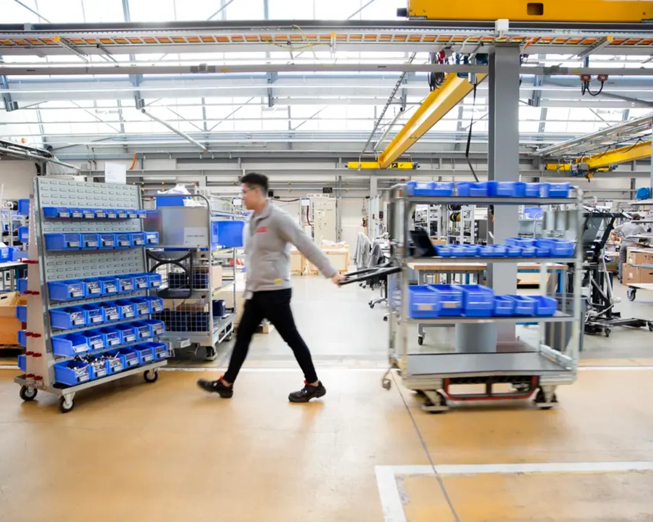 Milk Runner läuft durch moderne Lagereinrichtung, um Behälter in der Produktionshalle aufzufüllen