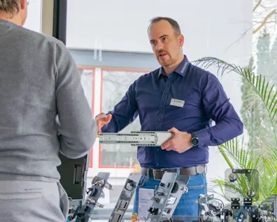 Mitarbeiter von Bossard demonstriert einem Besucher technische Komponenten bei einem persönlichen Beratungsgespräch während eines TechDay-Events.