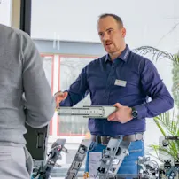 Bossard employee presenting technical components to a visitor during a personal consultation at a TechDay event.