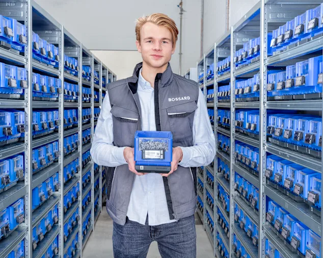 Man standing in supermarket area holding a SmartBin Cloud in its hands.