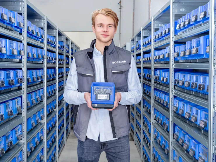Man standing in supermarket area holding a SmartBin Cloud in its hands.