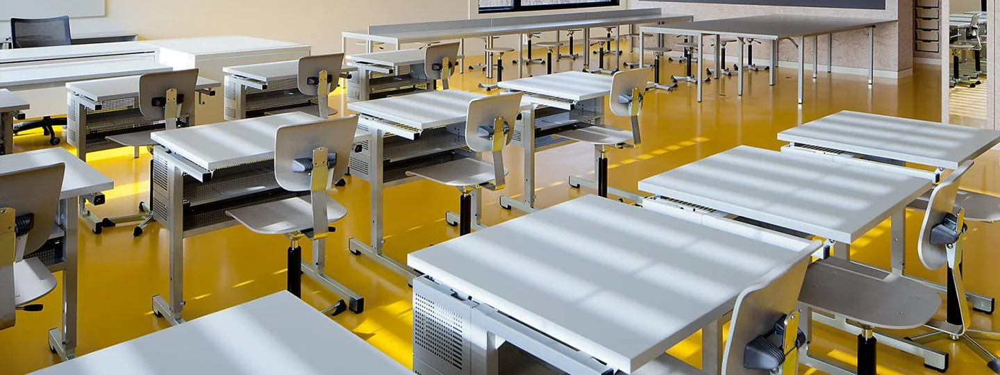 Une salle de classe bien agencée présentant divers bureaux et chaises, créant un environnement accueillant pour l'apprentissage et la collaboration.