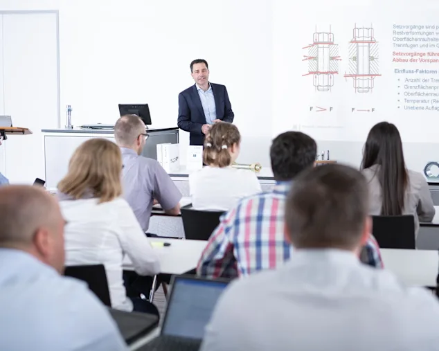 Personen in einem Klassenzimmer, die an einem Seminar über Befestigungstechnik teilnehmen. Schlüsselbild nur für Expert Education.