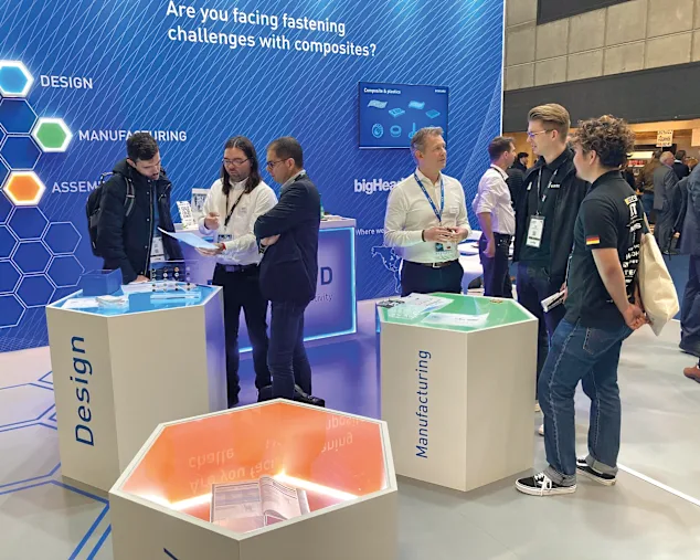 Bossard booth with people discussing fastening solutions at the JEC World in Paris, a leading composites trade show.