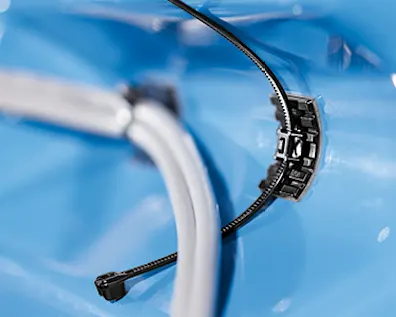Cận cảnh giá đỡ dây cáp HellermannTyton FlexTack trên nền xanh, thể hiện sự cố định đáng tin cậy của dây cáp.