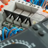 Nahaufnahme von elektrischen Verkabelungen und Geräten, die komplexe Verbindungen und wesentliche Komponenten für die Stromverteilung hervorheben.