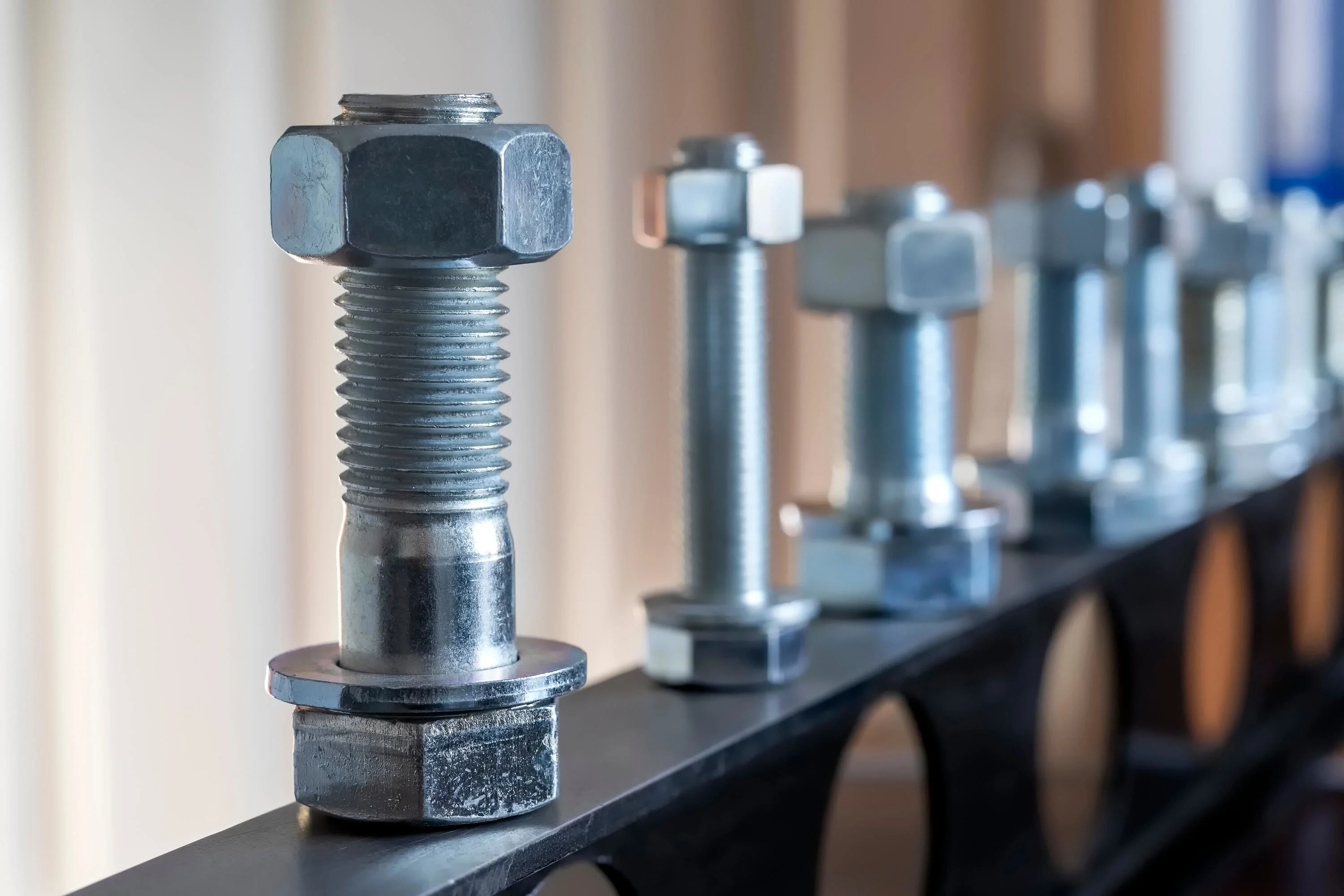 Vista di elementi di fissaggio: bulloni, dadi e rondelle. I bulloni assemblano due componenti non filettati con un dado, mentre le viti sono utilizzate con componenti filettati.