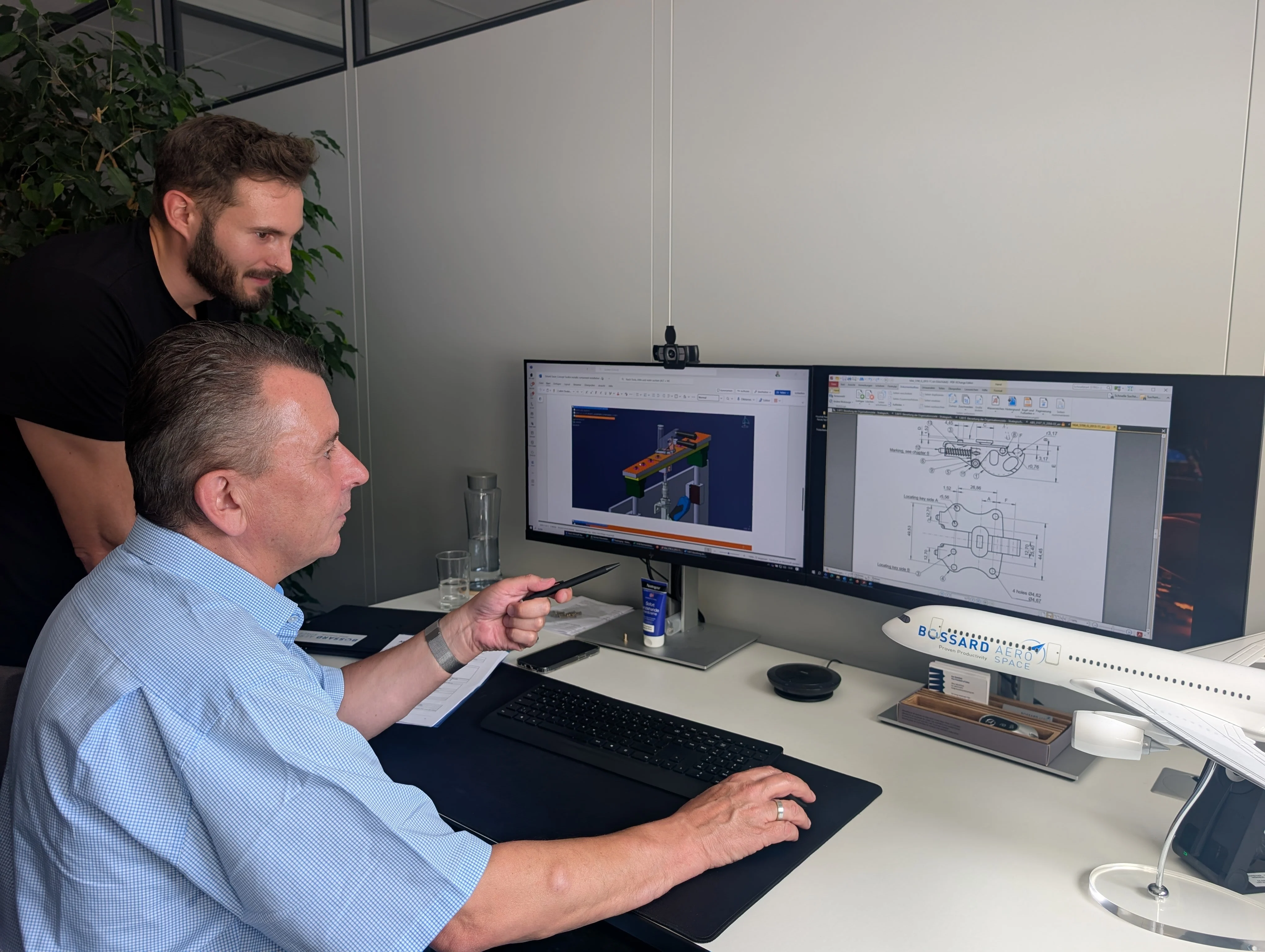 Two people discussing about aerospace related drawing on the screen