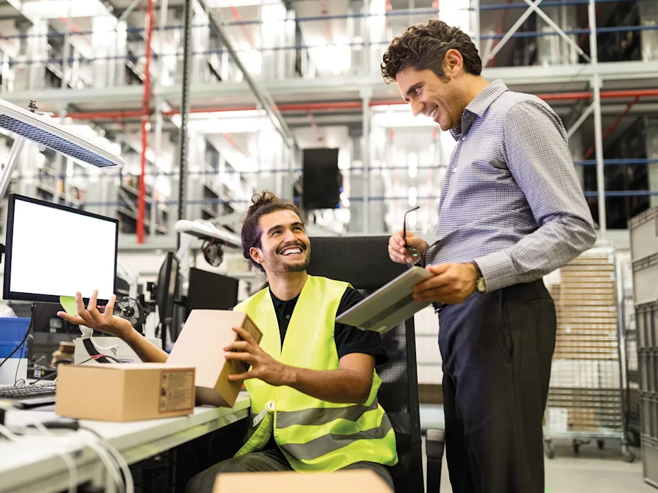 Warehouse manager and worker talking about order picking