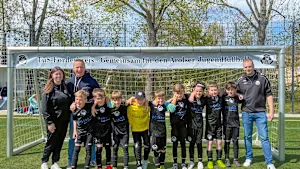 Gruppenfoto einer Jugendfußballmannschaft des TuS Bad Arolsen mit Betreuern vor einem Fußballtor.
