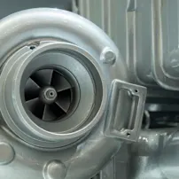 Nahaufnahme eines Turbomotors mit einem markanten Turbolader, der komplexe Details und Ingenieursdesign zeigt.