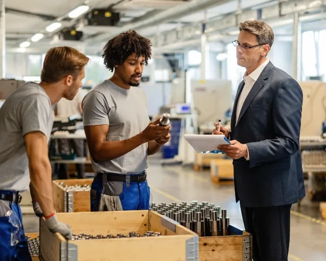 tre personer diskuterer et parti af bearbejdede emner