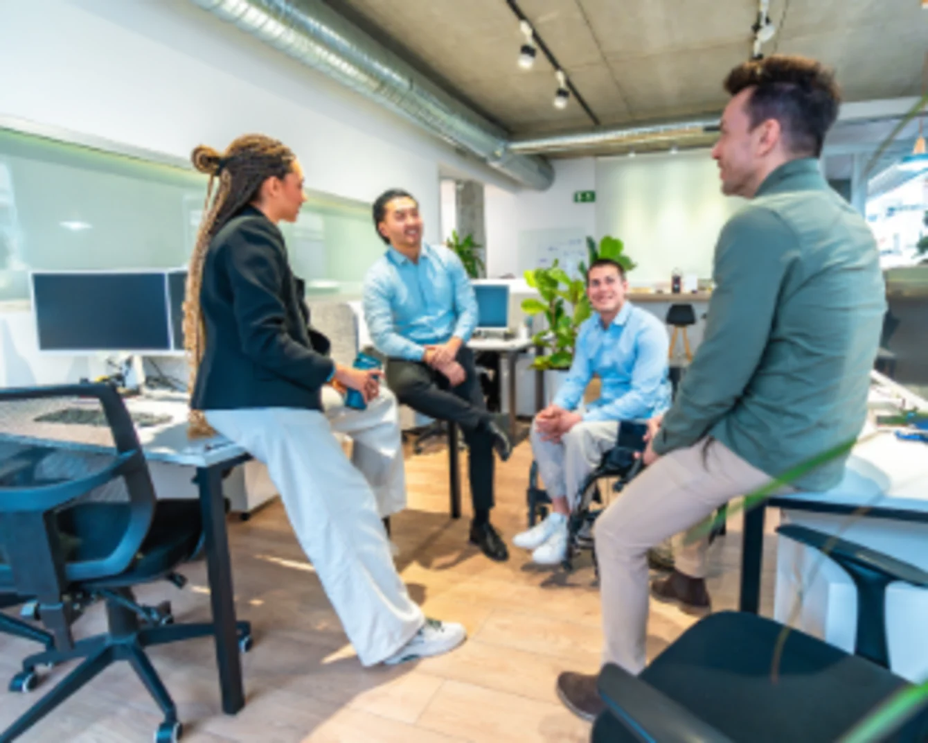 Quatre personnes en discussion au bureau