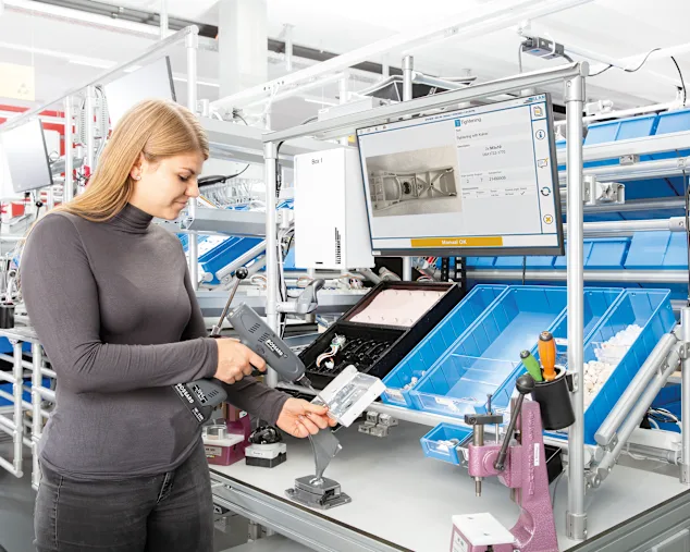 Femme utilisant un outil intelligent guidée par les instructions de travail ELAM Solutions à travers le processus.