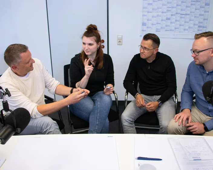 Andreas Reiger and Dirk Ockel diskutieren mit Podcast-Moderatoren über Befestigungslösungen vor Mikrofonen