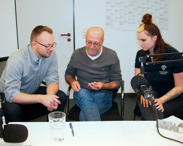 Gruppe von Fachleuten bei einer Podcast-Aufnahme engagiert in einer Diskussion