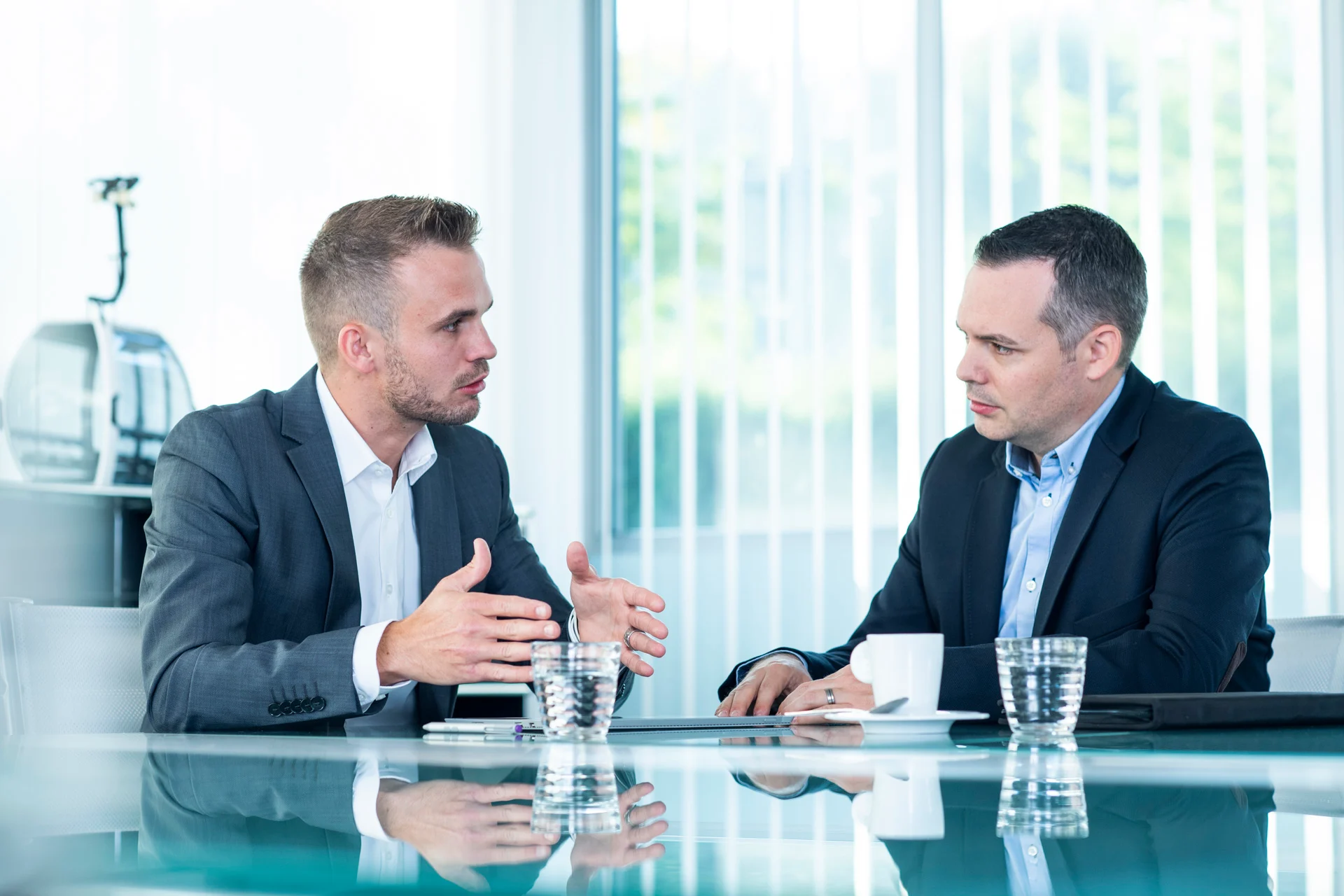 Zwei Geschäftsleute sitzen an einem Tisch in einer Konferenz und tauschen Ideen aus.
