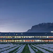 Integra Firmengebäude bei Dämmerung mit Bergen im Hintergrund