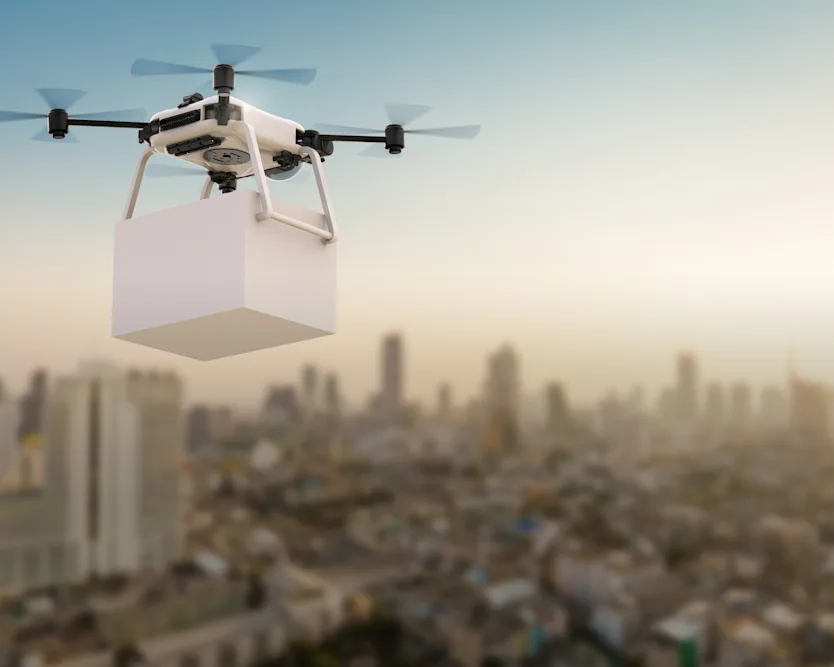 Futuristický dron vznášející se nad městskou krajinou, symbolizující pokrok v technologii doručování drony.