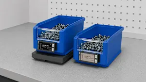 Deux bacs de stockage en plastique bleu remplis de vis, chacun avec une étiquette d'affichage numérique indiquant les numéros d'inventaire et les quantités.