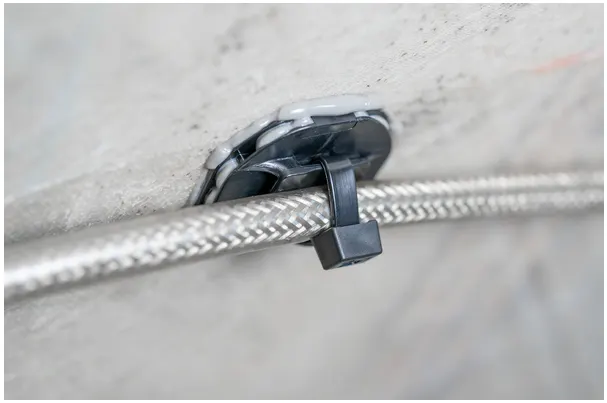 Close up of a HellermannTyton paste adhesive mount to securely fasten cables into place