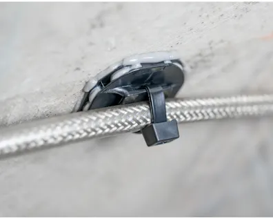 Cận cảnh một giá đỡ keo dán HellermannTyton để cố định cáp chắc chắn.