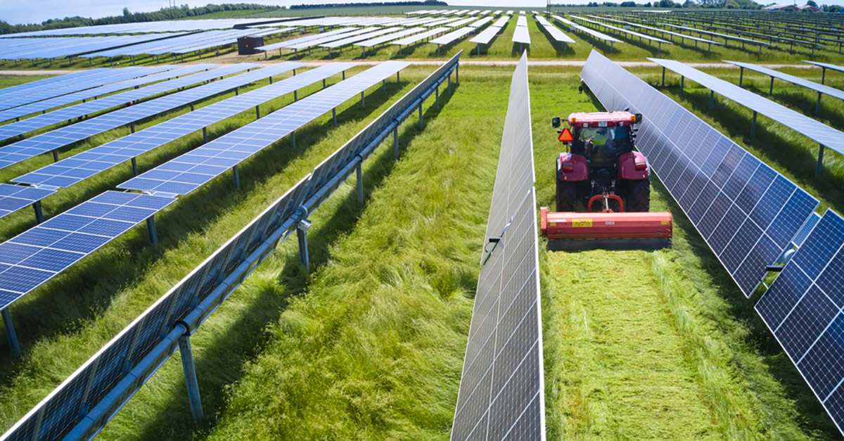 tractor in a field with solar panels