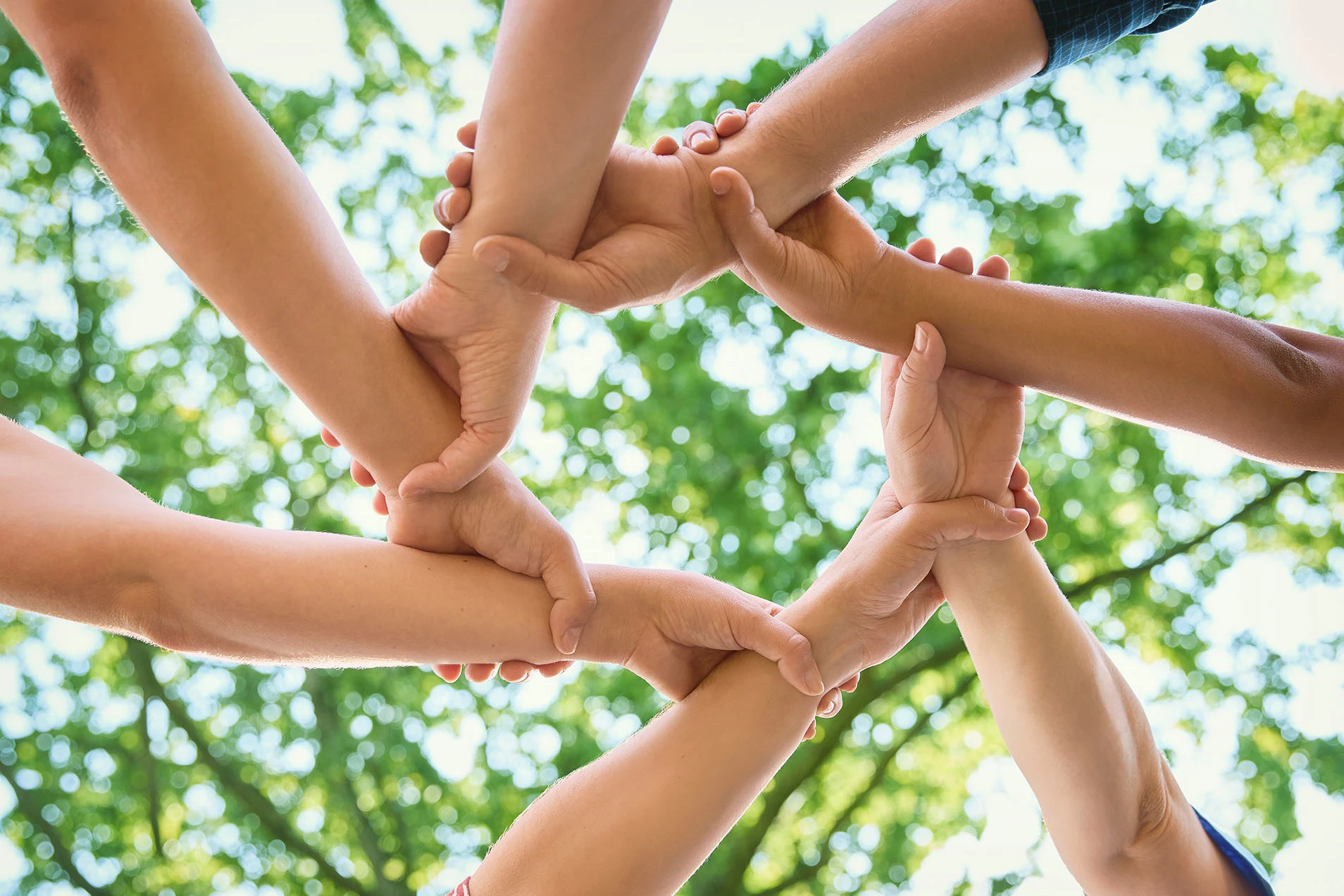Menschen halten sich gemeinsam an den Armen