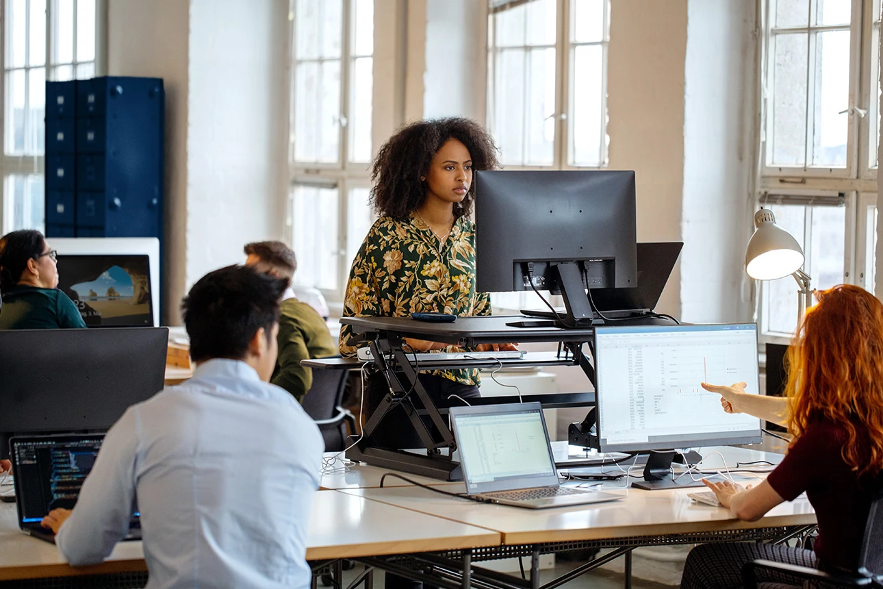 Vier Personen arbeiten zusammen im Büro und sitzen sich dabei gegenüber