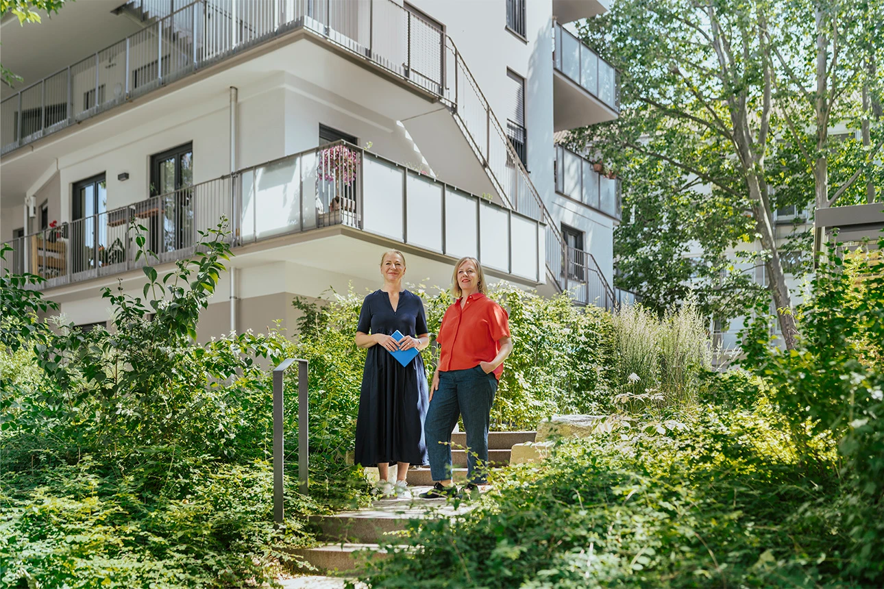 Frauen stehen vor einem nachverdichteten Wohngebäude