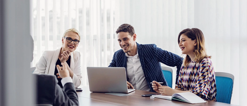 Drei Personen arbeiten gemeinsam am Laptop