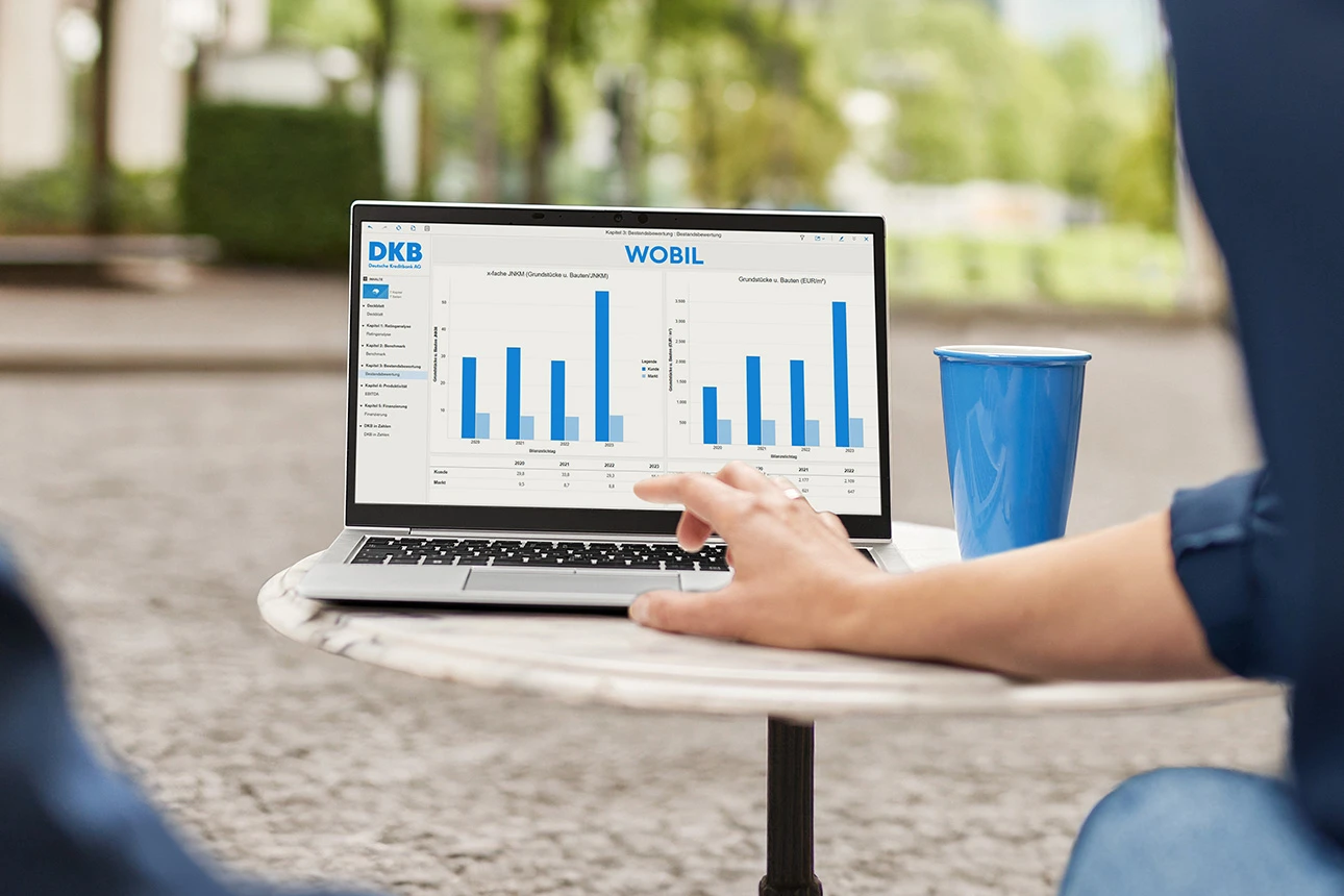Personen vor Laptop mit wohnwirtschaftlicher Bilanzanalyse DKB WOBIL