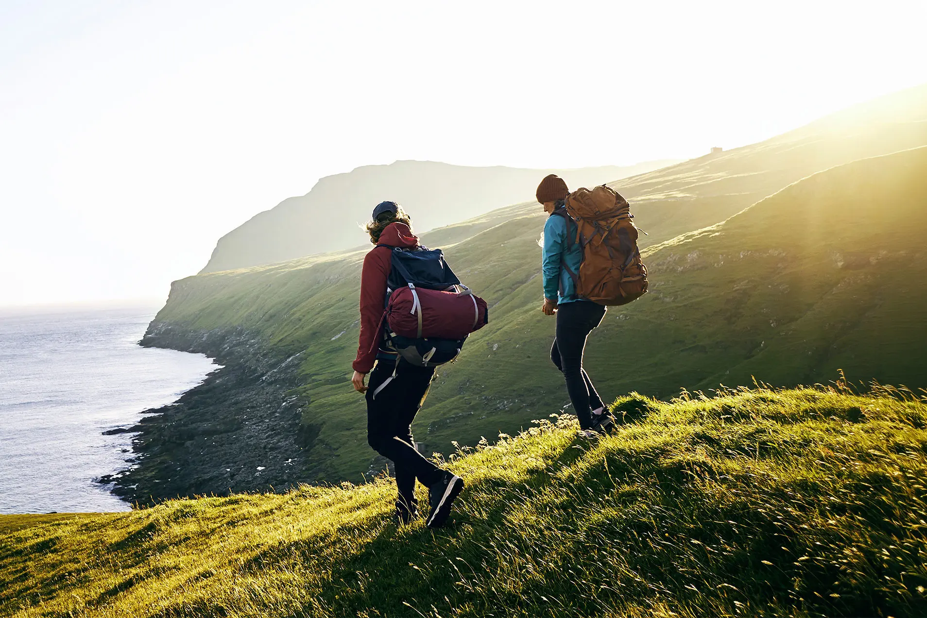 Zwei Personen wandern in einer grünen Landschaft