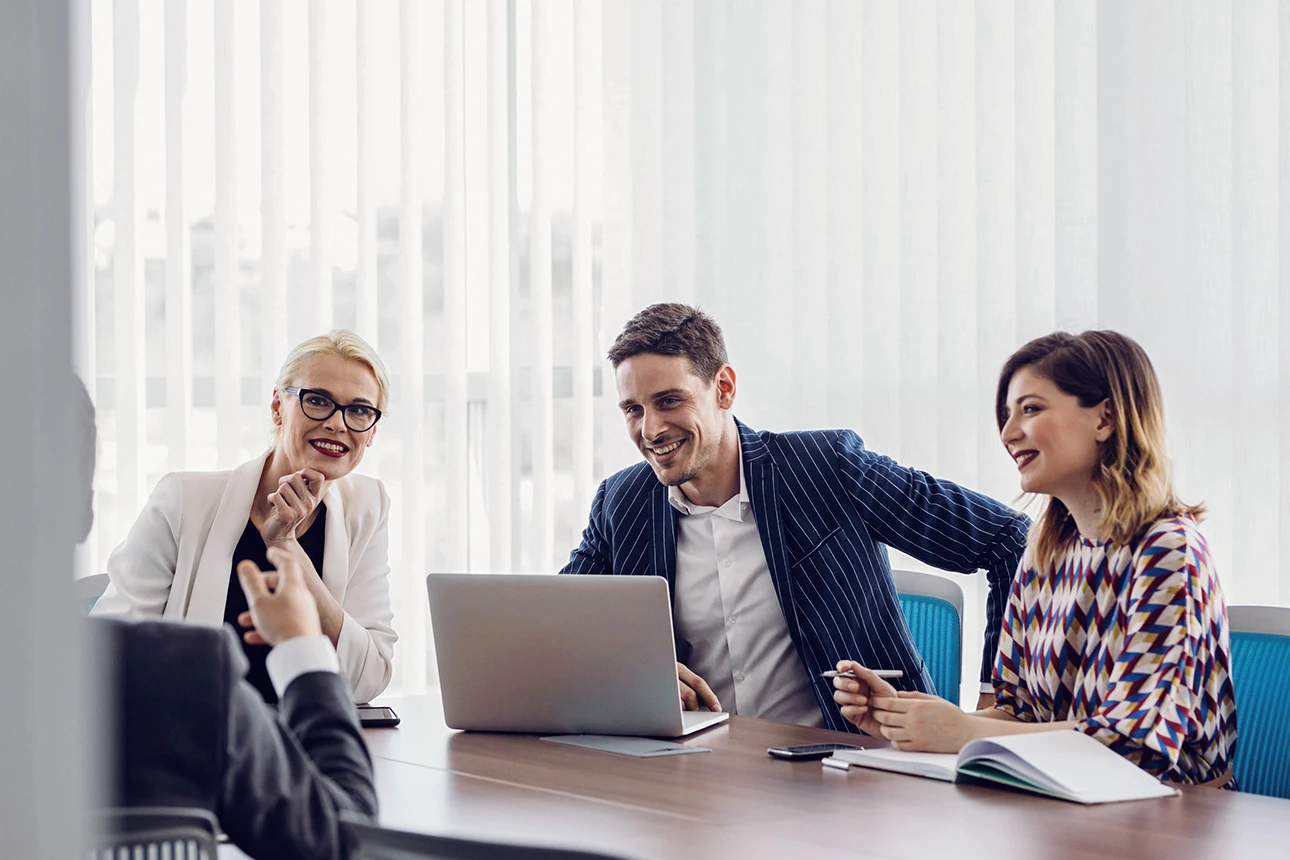Drei Personen arbeiten gemeinsam am Laptop
